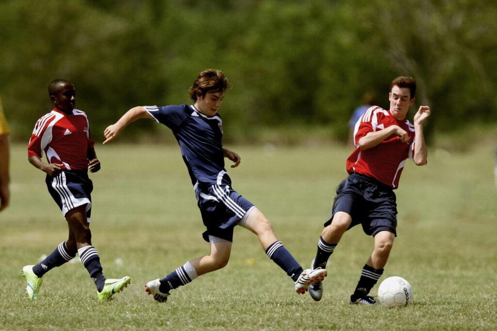 teen boys playing soccer without sports guards might need to visit our emergency dentist in Missouri City, TX